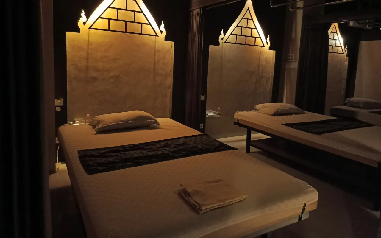 Ruang terapi Polaris yang temaram dengan headboard gunungan menyala hangat di atas tempat tidur pijat
